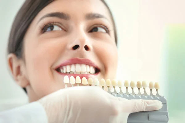 Dentist matching teeth colour in office — Stock Photo, Image