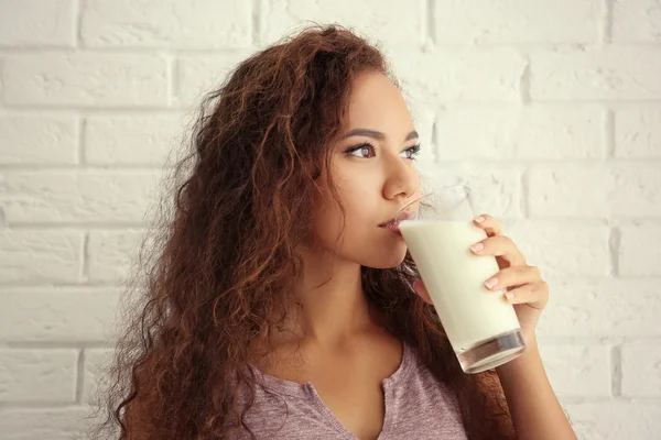 Attraente giovane donna africana con vetro di latte — Foto Stock