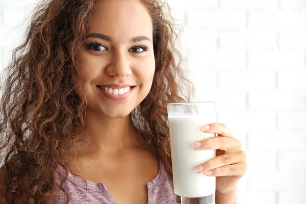 Jovem mulher africana atraente com copo de leite — Fotografia de Stock