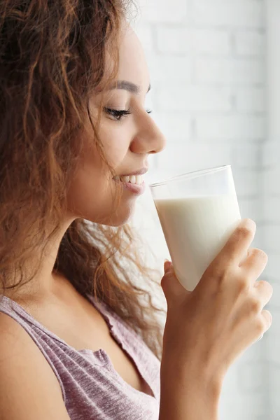 Attractive young African woman with glass of milk — Stock Photo, Image
