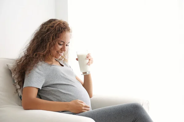 Attractive pregnant African woman with glass of milk — Stock Photo, Image