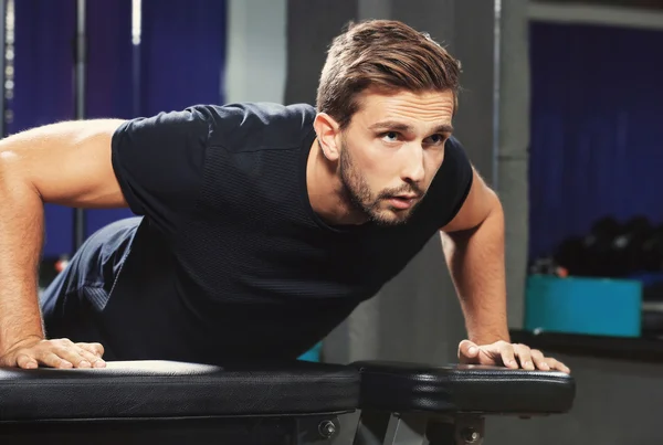 Handsome man doing push ups in gym — Stock Photo, Image
