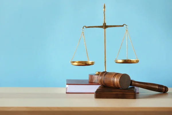 Escalas de justiça, martelo do juiz e livro sobre mesa de madeira e fundo azul — Fotografia de Stock