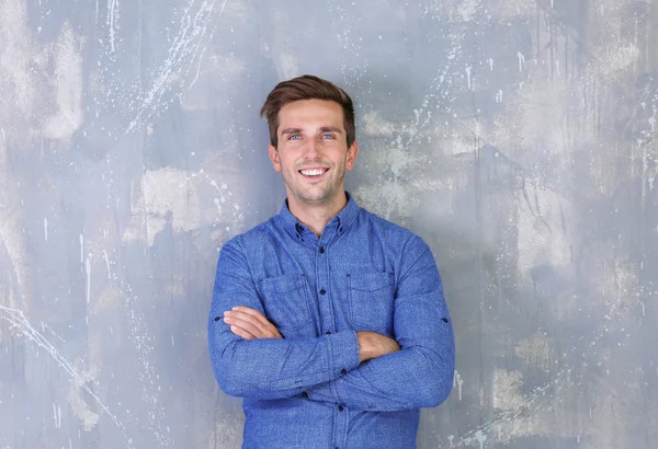 Joven hombre de negocios feliz sobre fondo de pared gris —  Fotos de Stock