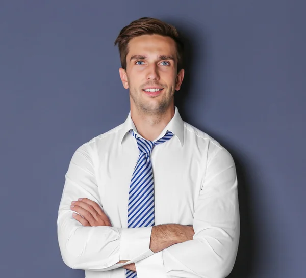 Young happy businessman on grey background — Stock Photo, Image