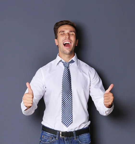 Young happy businessman on grey background — Stock Photo, Image