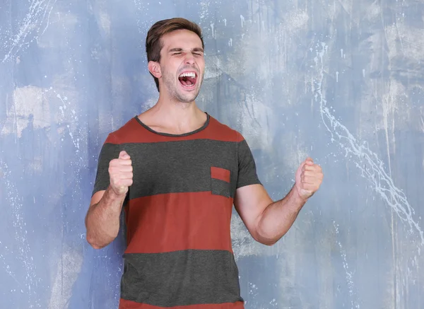 Young handsome man on grey wall background — Stock Photo, Image