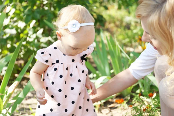 Lycklig mamma med dotter vilar i parken på solig dag — Stockfoto