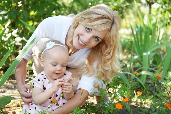 Mãe feliz com a filha descansando no parque no dia ensolarado — Fotografia de Stock