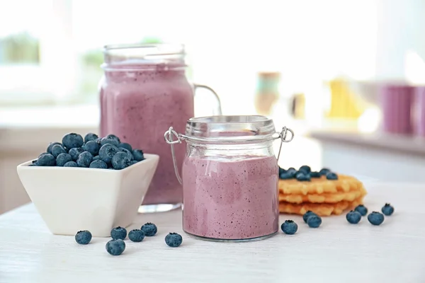 Hälsosam frukost med blueberry smoothie och rån på köksbordet — Stockfoto