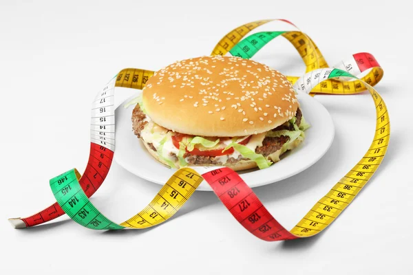 Hamburger with centimeter on plate — Stock Photo, Image