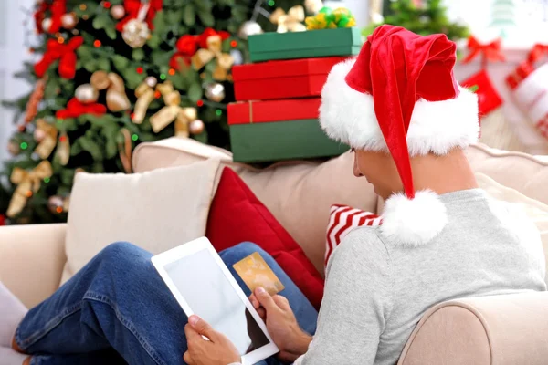 A fiatalember internetes vásárlás bankkártyával otthon karácsonyra — Stock Fotó