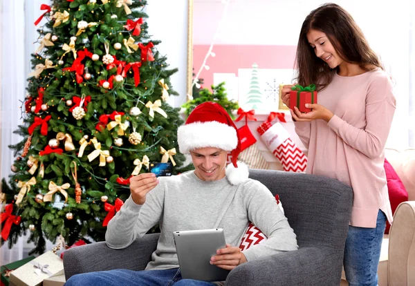 年轻夫妇在线购物用信用卡在家里过圣诞 — 图库照片