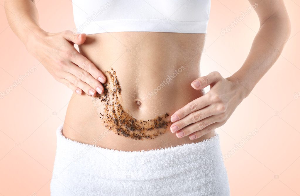 Young woman applying scrub on body against color background. Skin care concept.