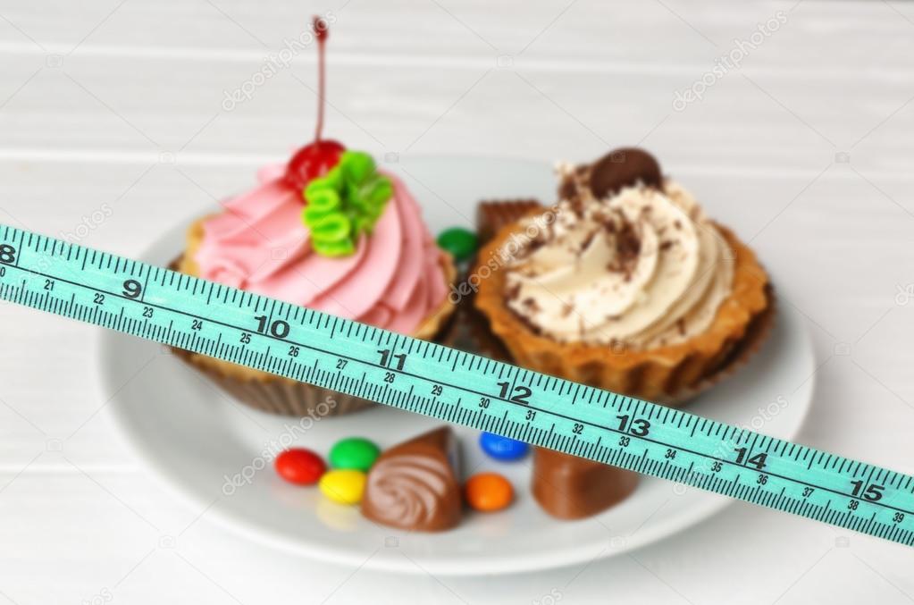 Measuring tape and plate with delicious cakes