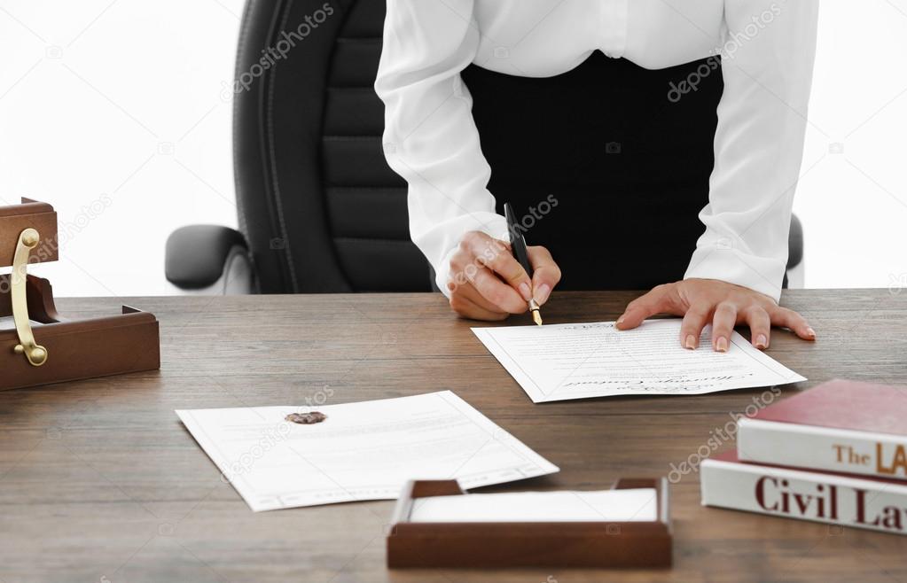 Female lawyer signing documents in office, close up view