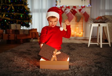 Noel Baba şapkası ile Noel hediyesi evde şirin küçük çocuk