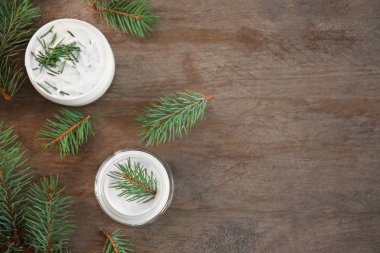 Ahşap zemin üzerine krema ve çam dalları