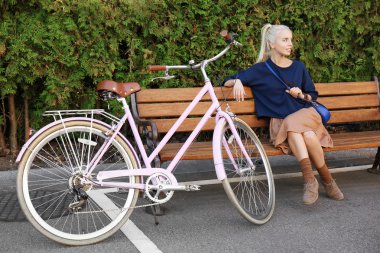 Genç bisikletçi parkta bankta oturmuş