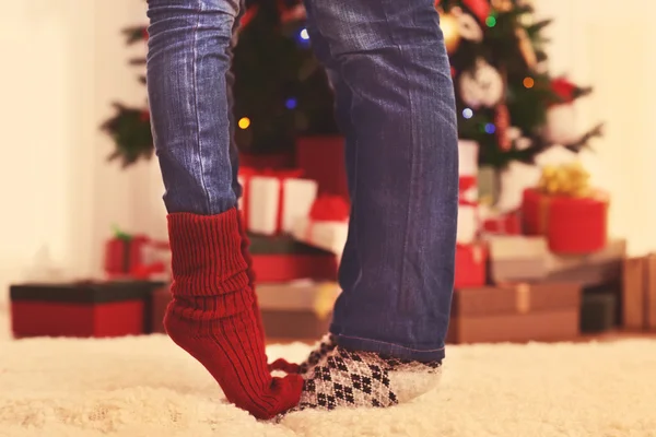 Piernas de pareja en la alfombra de piel en la habitación con árbol de Navidad y cajas de regalo —  Fotos de Stock