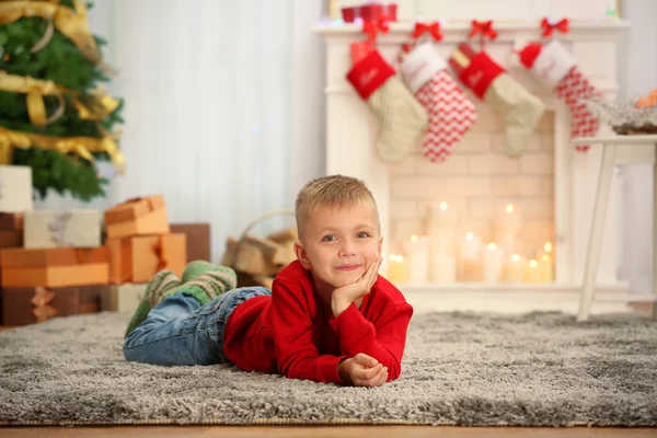 Schattige kleine jongen liggend op tapijt thuis — Stockfoto