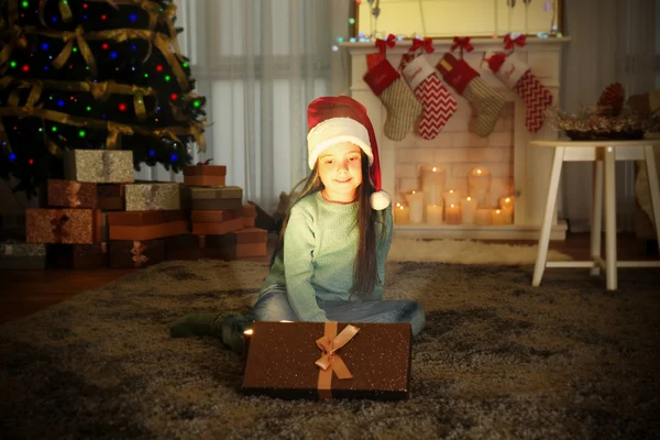 Ładna dziewczynka w Santa hat z Boże Narodzenie obecny w domu — Zdjęcie stockowe