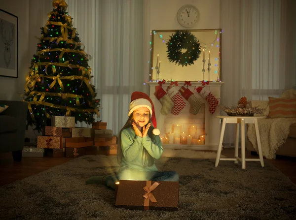 Ładna dziewczynka w Santa hat z Boże Narodzenie obecny w domu — Zdjęcie stockowe