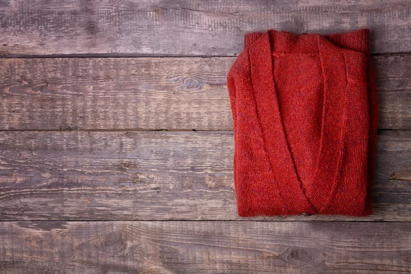 Jaqueta vermelha quente no fundo de madeira — Fotografia de Stock