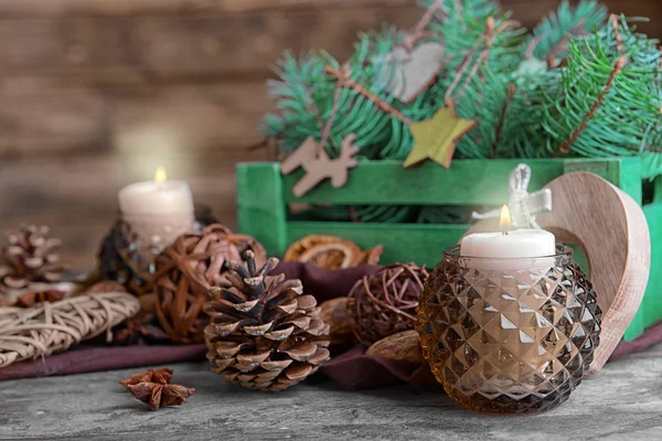 Composition of candle and natural decor on wooden background, close up view — Stock fotografie