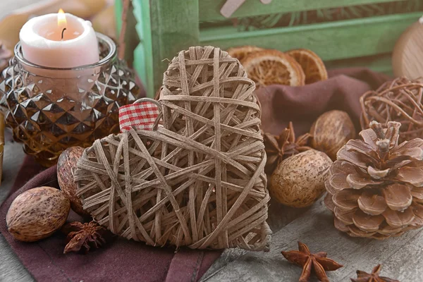 Composition of wicker heart and natural decor on wooden background, close up view — Stock fotografie