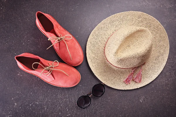 Червоне взуття, солом'яний капелюх та сонцезахисні окуляри на сірому фоні — стокове фото