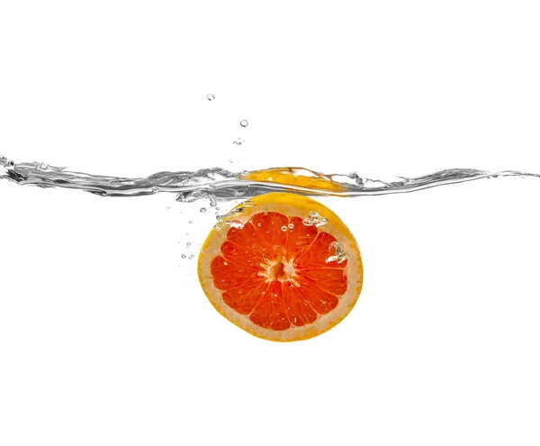 Grapefruit fällt ins Wasser auf weißem Hintergrund — Stockfoto