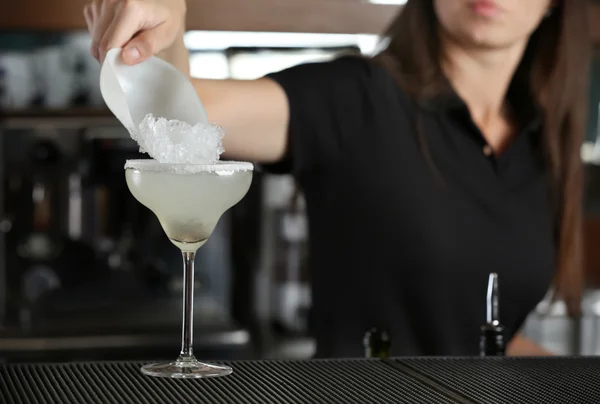 Le mani di donna aggiungono il ghiaccio nel cocktail sul bancone del bar — Foto Stock