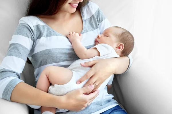Genç ve güzel kadın holding uyuyan bebek evde portresi — Stok fotoğraf
