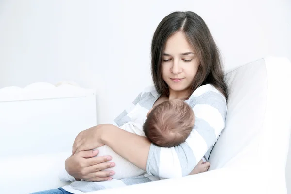 Ritratto di bella giovane donna che tiene in braccio il bambino addormentato a casa — Foto Stock