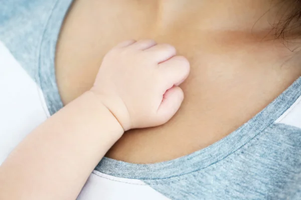 Крупним планом вид милою дитячою рукою на жіночі груди — стокове фото