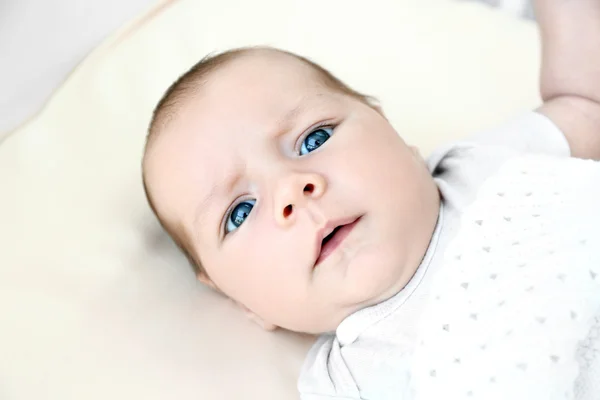 Porträt eines süßen Babys, das auf dem Bett liegt — Stockfoto