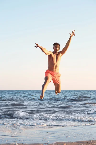 Gelukkig man springen op strand — Stockfoto