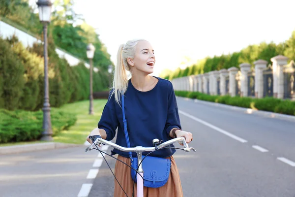 Młoda kobieta, jazdy na rowerze wzdłuż drogi — Zdjęcie stockowe