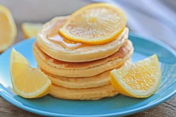 Piring dengan pancake lezat dan irisan lemon di atas meja kayu, close up view — Stok Foto