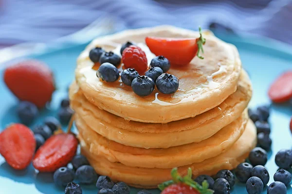 Tasty pancakes with berries on blue plate, close up view — Stock Photo, Image