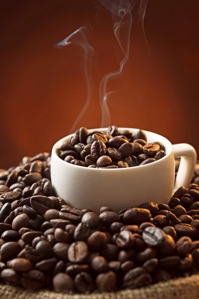 Fehér kupa és a kávészemek sötét háttér, zár-megjelöl kilátás — Stock Fotó