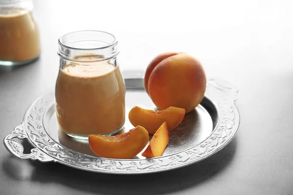 Винтажный поднос с вкусным смузи и персиком на столе — стоковое фото