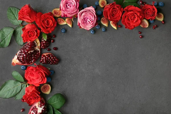 Composition de roses, figues et morceaux de grenade sur fond gris texturé — Photo