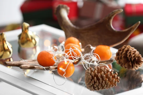 Mandarini e coni sul tavolo in camera decorata — Foto Stock