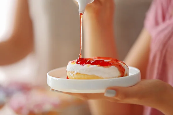 Mulher derramando saboroso donut com geléia, vista de perto — Fotografia de Stock