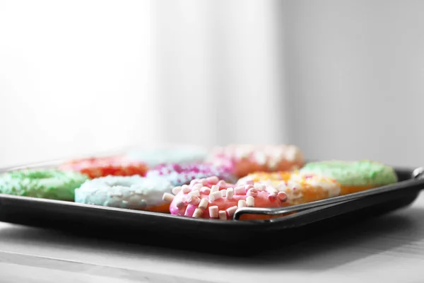 Baking pan with tasty donuts on blurred background, close up view — Stock Photo, Image