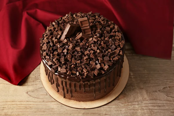 Savoureux gâteau au chocolat et serviette rouge sur fond en bois — Photo