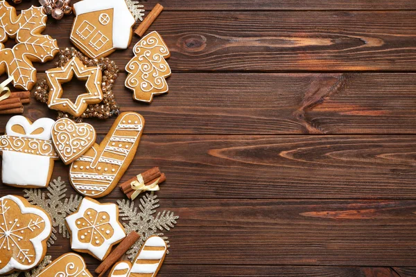 Gustosi biscotti di pan di zenzero e decorazioni natalizie su sfondo di legno — Foto Stock