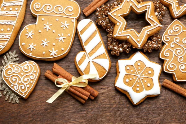 Sabrosas galletas de jengibre y decoración de Navidad sobre fondo de madera, de cerca — Foto de Stock